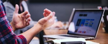 person discussing with laptop at the table