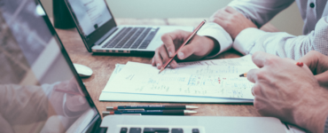 people writing while working on laptop