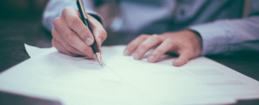 man writing on paper for working agreement